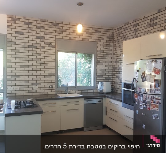מטבח עם קירות לבנים, ארונות ומשטחי עבודה